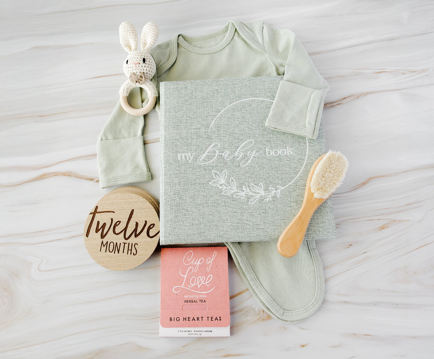 baby gift flatlay on a wood background